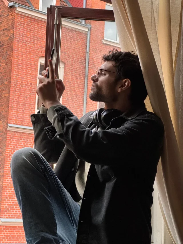 Am Fenster mit Smartphone fotografieren