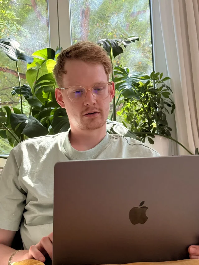 Konzentriert am Laptop zwischen Pflanzen